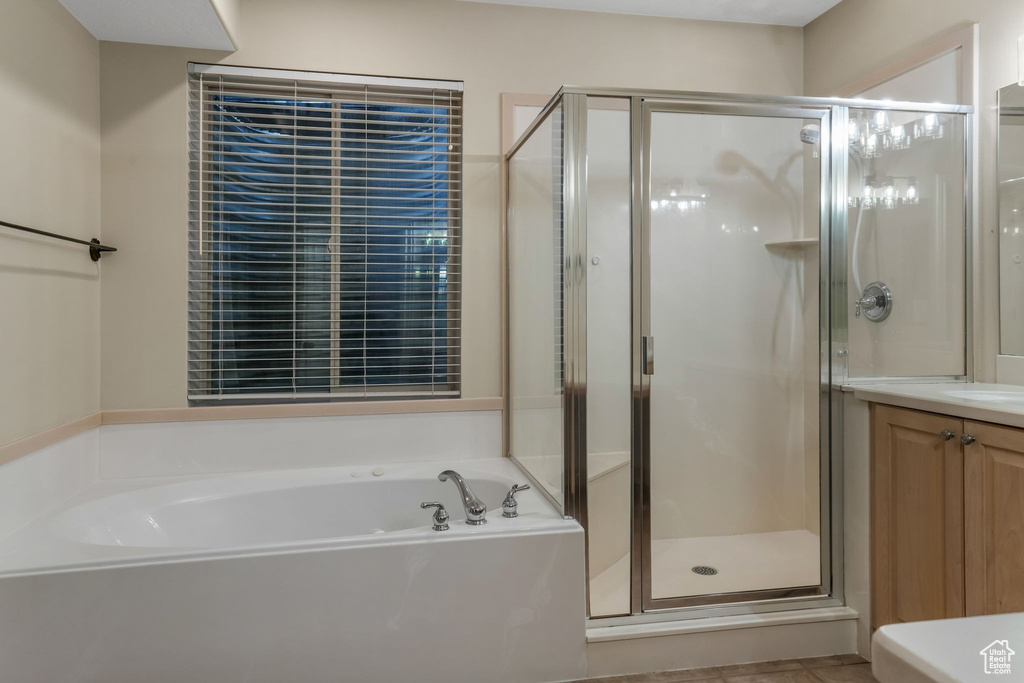 Full bathroom featuring a garden tub, a shower stall, and vanity