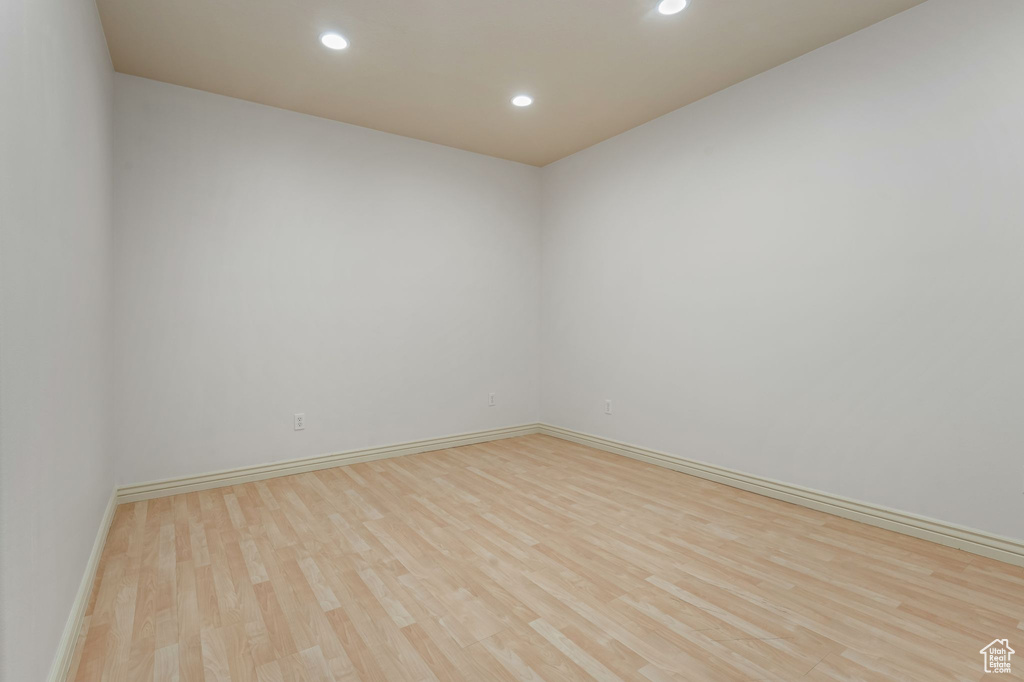 Empty room featuring wood finished floors, recessed lighting, and baseboards