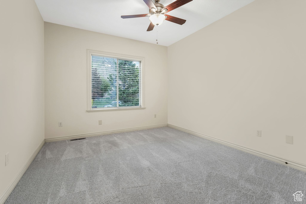 Spare room with ceiling fan, carpet, and baseboards