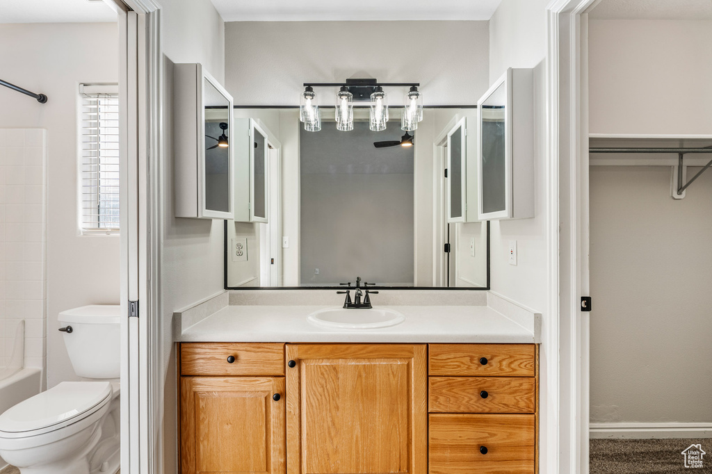 Bathroom featuring vanity, toilet, bathtub / shower combination, and baseboards