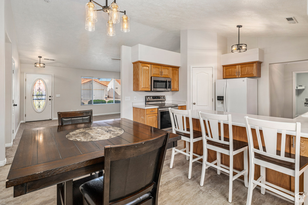 Dining room with lofted ceiling, baseboards, and a chandelier