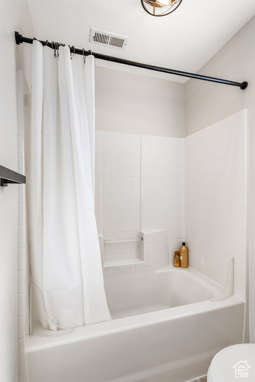 Full bathroom with shower / bath combo with shower curtain and toilet