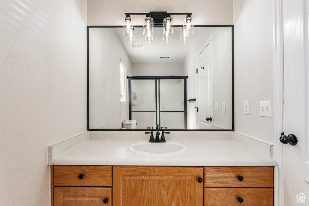 Bathroom featuring vanity and a shower with shower door