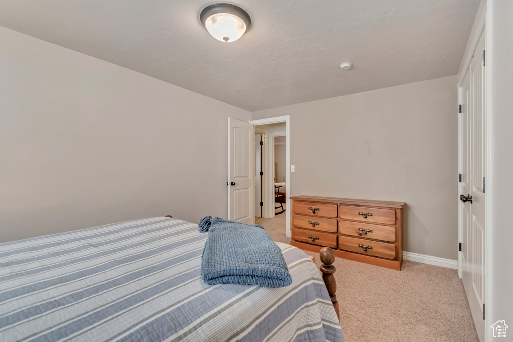 Bedroom with light carpet and baseboards