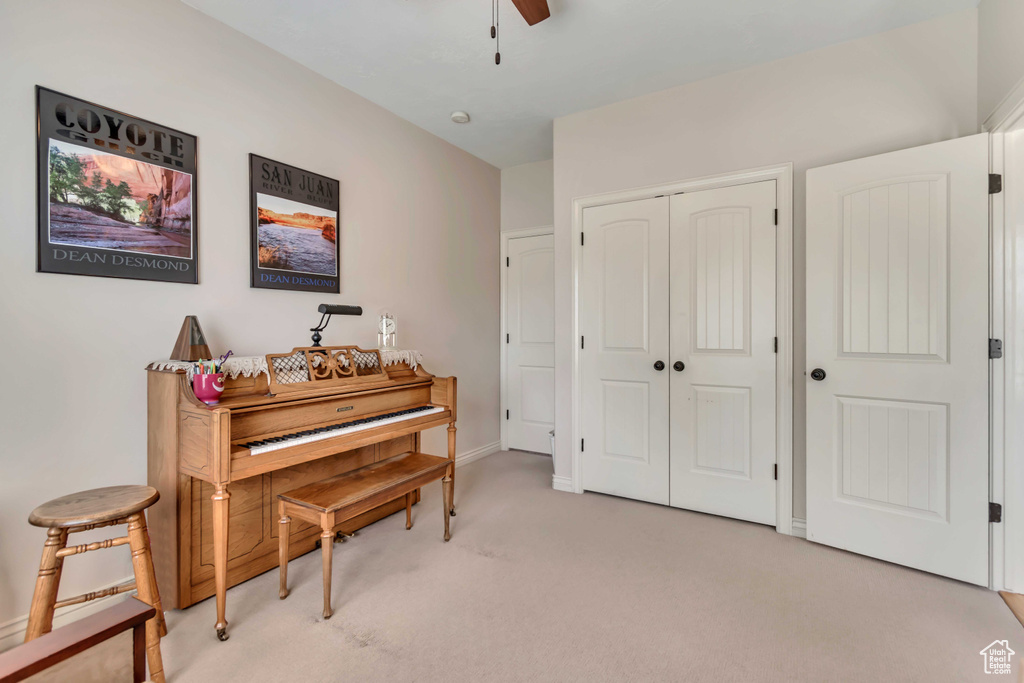 Sitting room with light carpet, ceiling fan, and baseboards