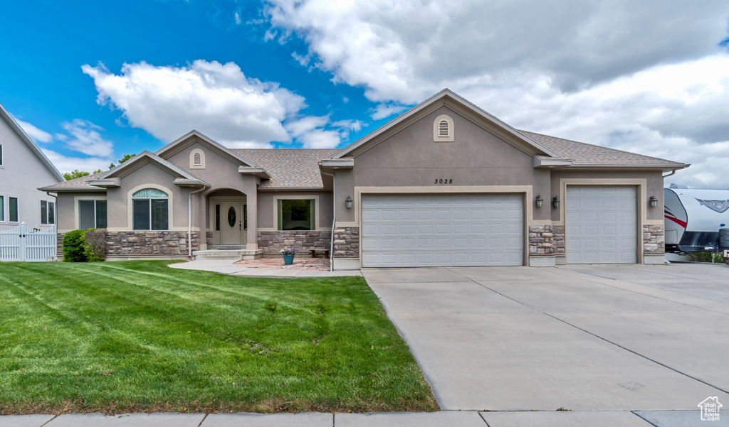 View of front facade featuring stucco siding, stone siding, a garage, concrete driveway, and a shingled roof