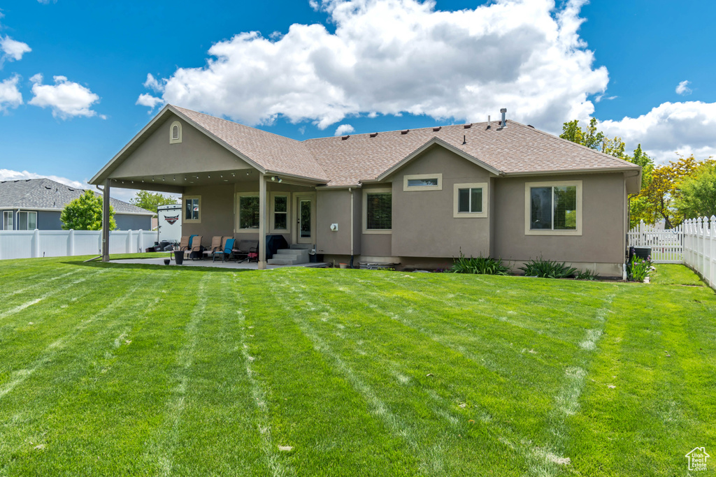 Back of property featuring a patio area, stucco siding, and roof with shingles