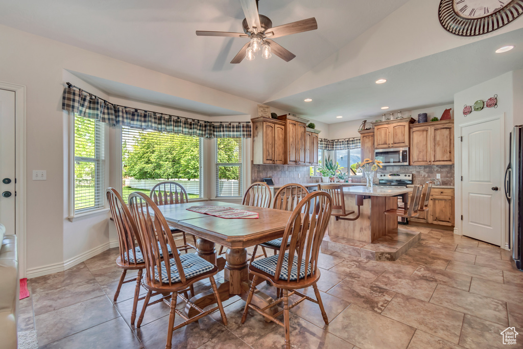 Dining room featuring plenty of natural light, vaulted ceiling, a ceiling fan, recessed lighting, and baseboards