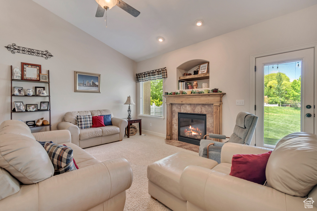 Carpeted living room with lofted ceiling, ceiling fan, a high end fireplace, baseboards, and recessed lighting