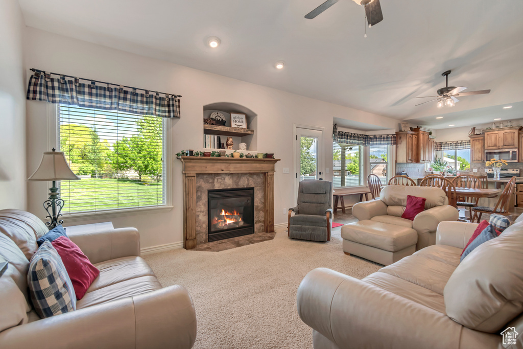 Carpeted living area featuring ceiling fan, baseboards, a premium fireplace, and recessed lighting