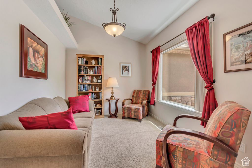 Living room featuring carpet flooring, lofted ceiling, and baseboards