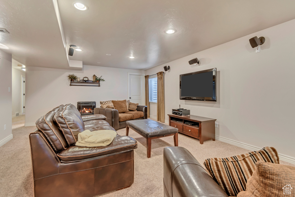 Living area with light colored carpet, baseboards, a lit fireplace, and recessed lighting