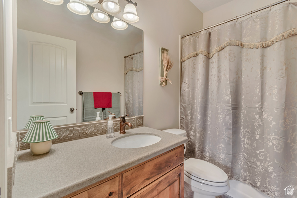 Full bathroom featuring toilet, vanity, and a shower with shower curtain