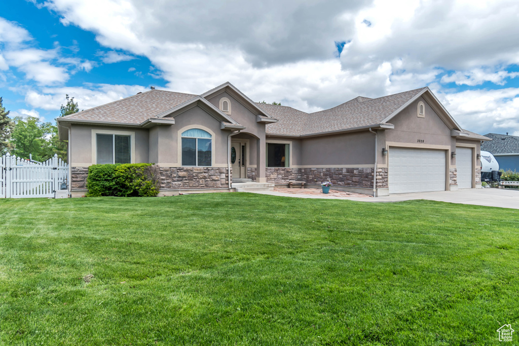 Single story home with stucco siding, an attached garage, stone siding, and concrete driveway