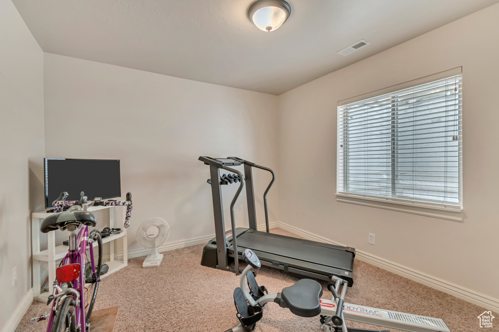 Exercise area with carpet floors and baseboards