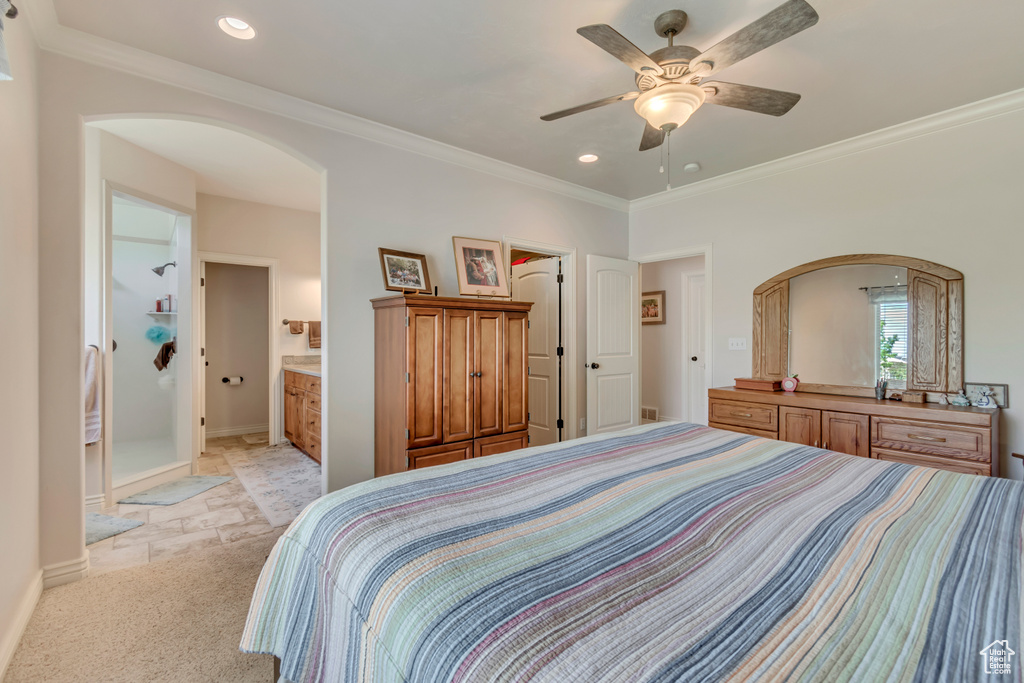 Bedroom with arched walkways, crown molding, recessed lighting, baseboards, and light carpet