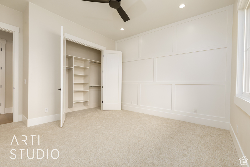Unfurnished bedroom featuring carpet floors, a decorative wall, recessed lighting, and ceiling fan