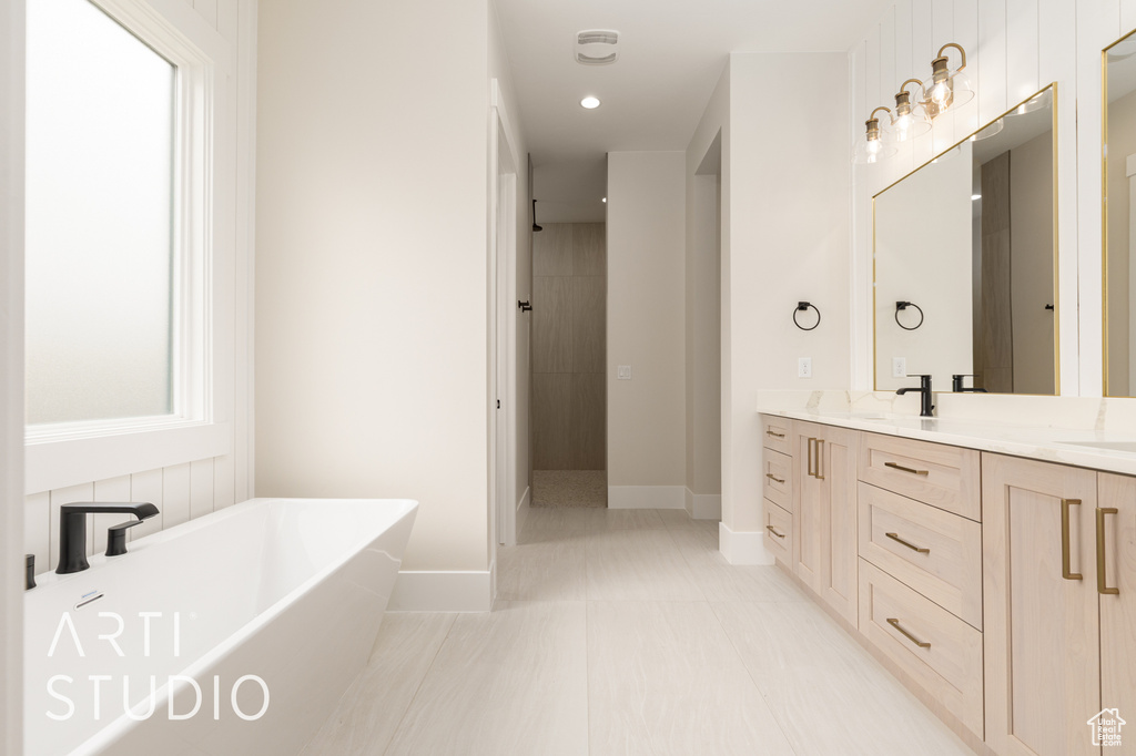 Bathroom featuring a freestanding bath, double vanity, a tile shower, baseboards, and recessed lighting