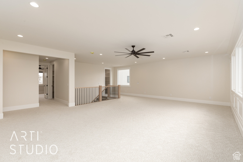 Empty room featuring recessed lighting, light carpet, a ceiling fan, and baseboards