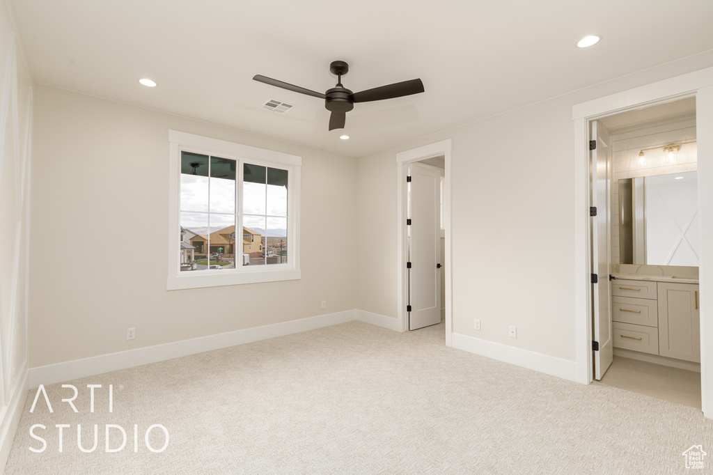 Unfurnished bedroom with light colored carpet, recessed lighting, baseboards, ensuite bath, and ceiling fan