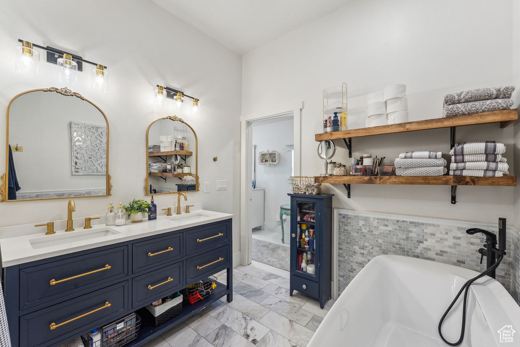 Bathroom with marble finish flooring, double vanity, and a freestanding bath