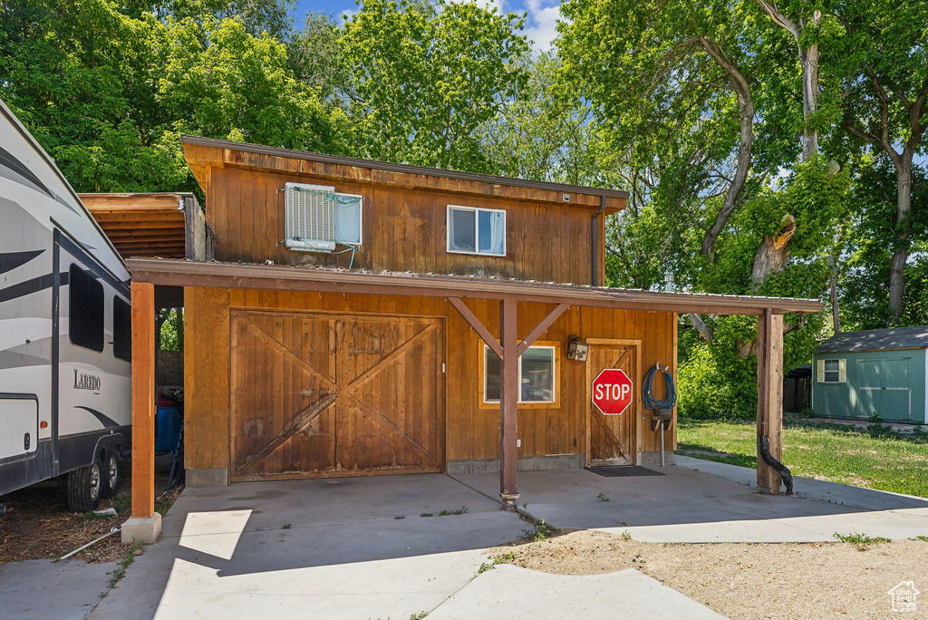 View of shed with concrete driveway