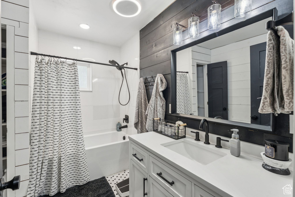 Full bathroom featuring vanity, shower / tub combo, and wood walls