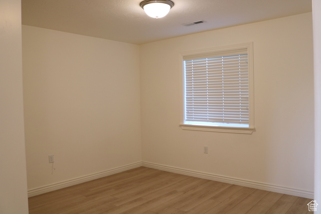 Spare room featuring light wood-type flooring and baseboards