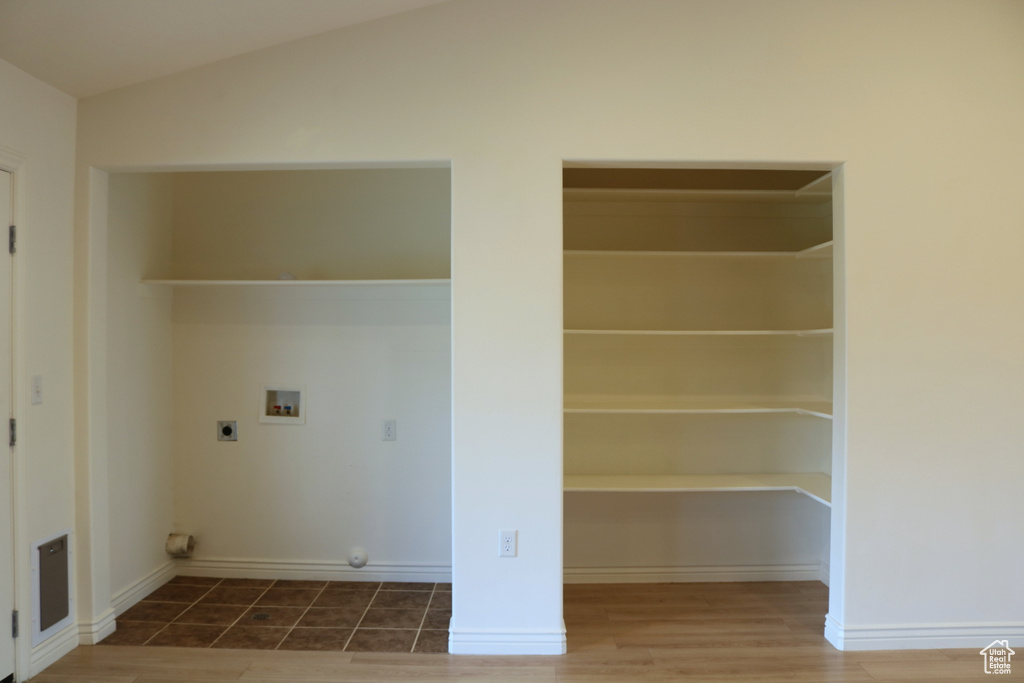 Laundry room with hookup for an electric dryer, hookup for a washing machine, and wood finished floors