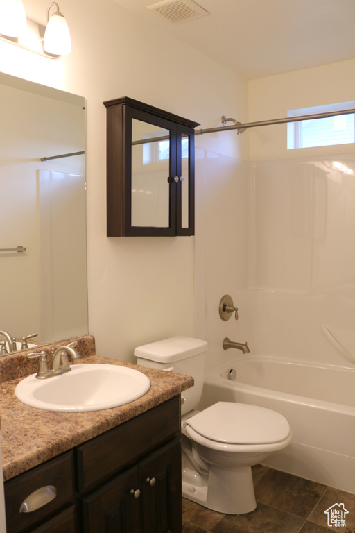 Bathroom featuring vanity, toilet, and bathing tub / shower combination