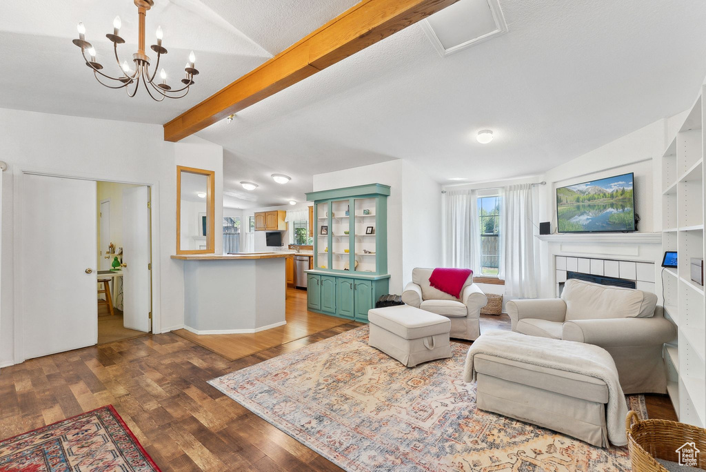 Living area featuring wood finished floors, a fireplace, a chandelier, and baseboards