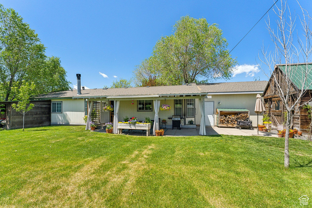 Back of house featuring a patio and a lawn
