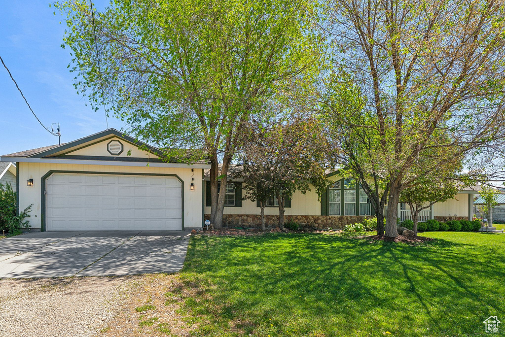 Single story home with driveway, a garage, and a front lawn