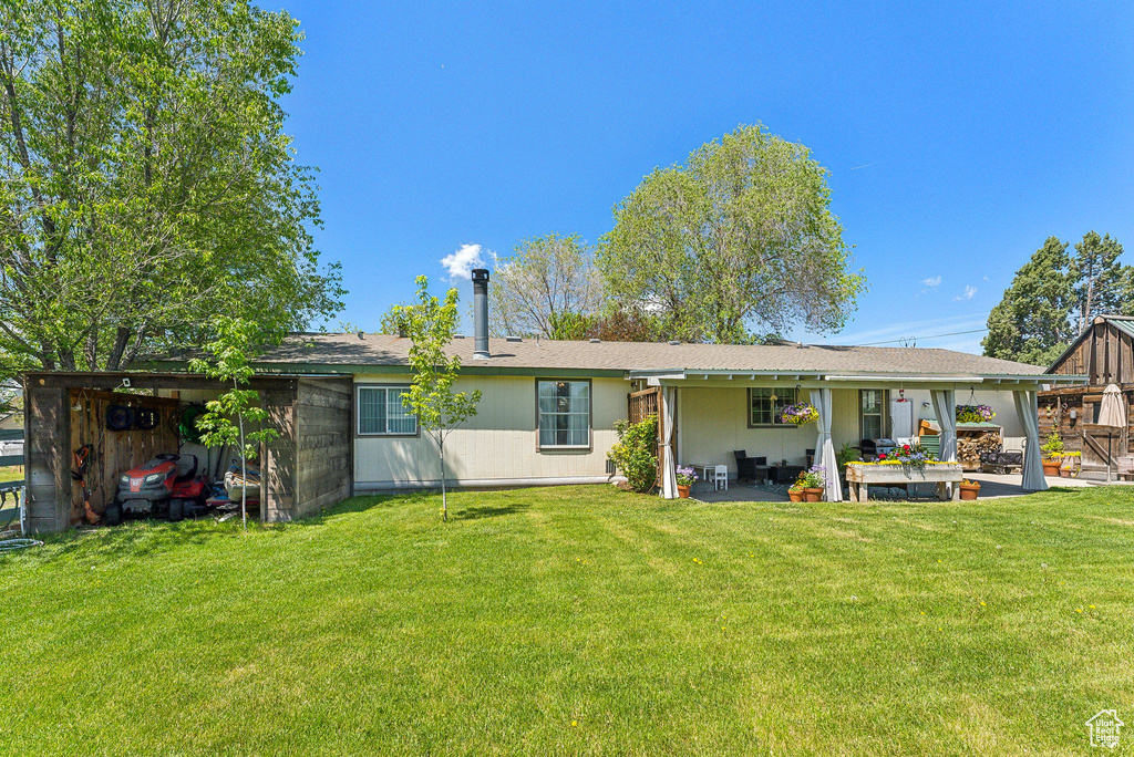 Rear view of house featuring a patio area and a lawn