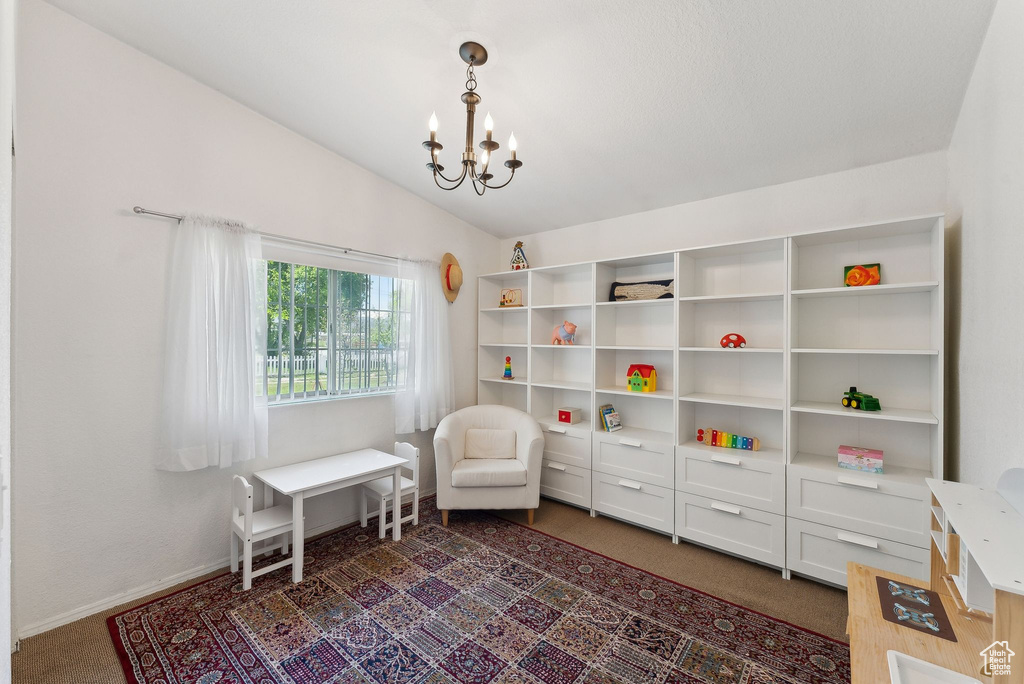 Sitting room featuring a chandelier, lofted ceiling, baseboards, and carpet