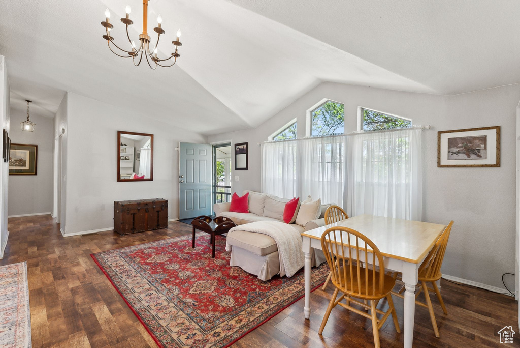 Living room featuring lofted ceiling, a chandelier, wood finished floors, and baseboards