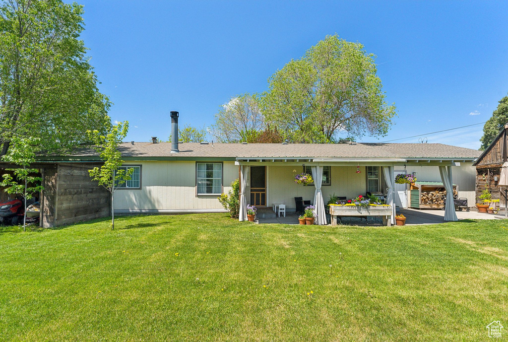 Back of property with a patio area and a lawn