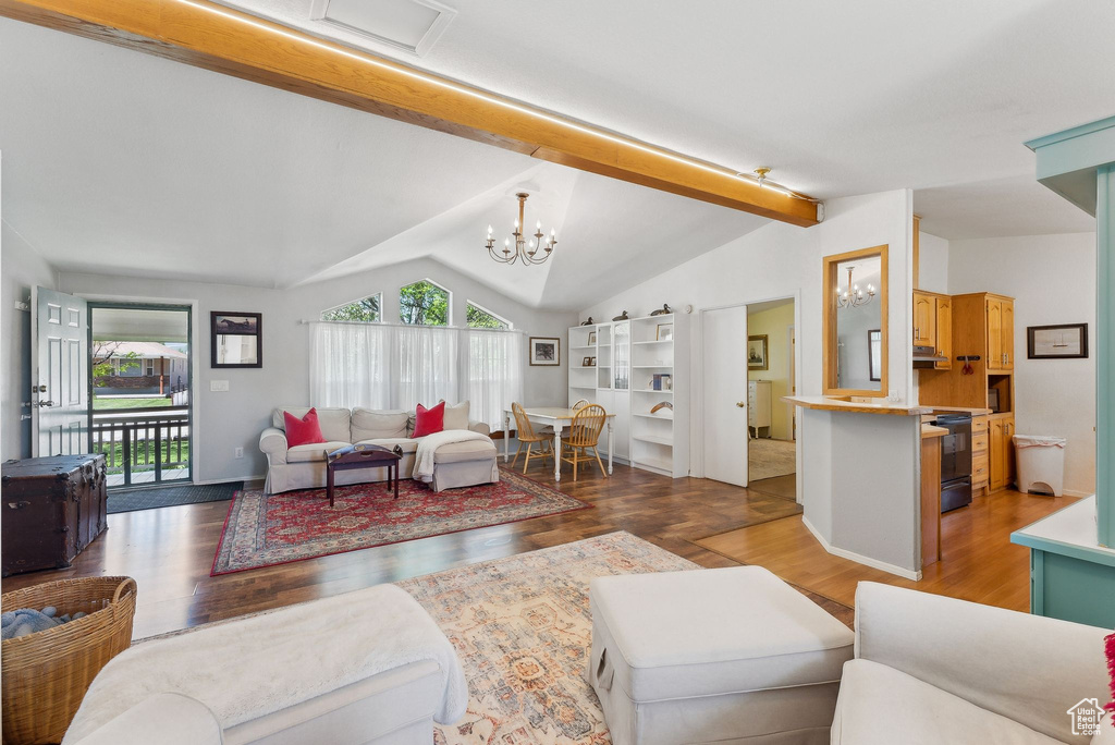 Living area featuring wood finished floors, a chandelier, and baseboards