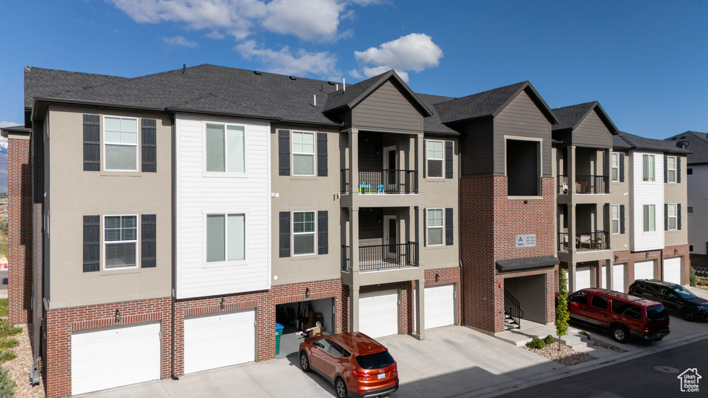View of building exterior featuring an attached garage and driveway