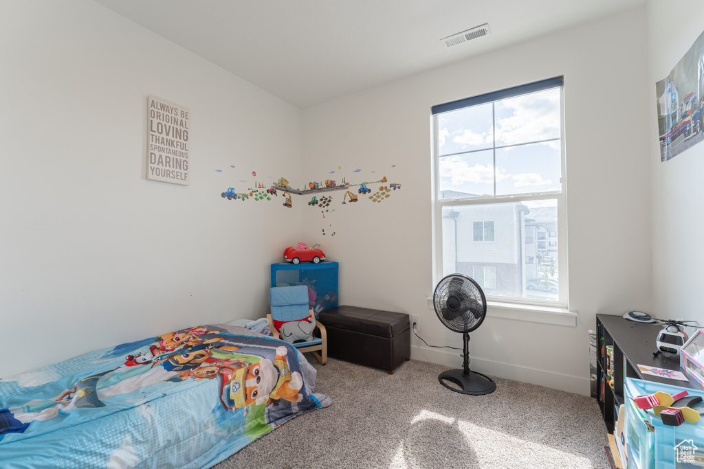 Carpeted bedroom featuring multiple windows and baseboards