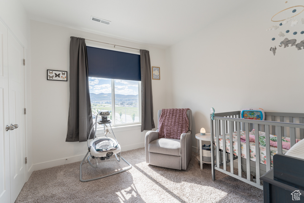 Carpeted bedroom with a nursery area and baseboards