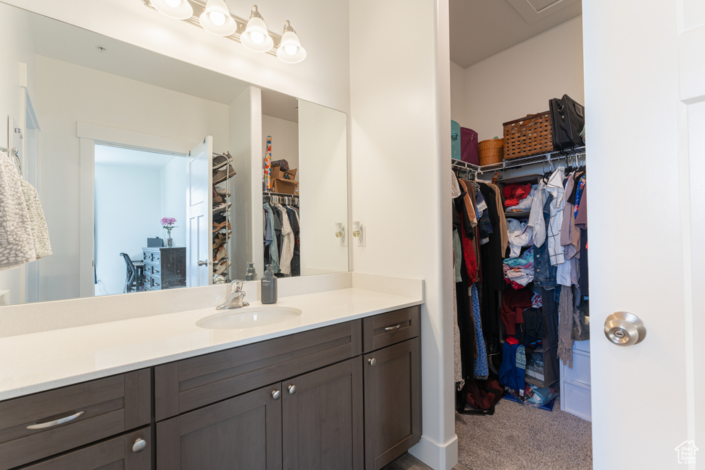 Bathroom with vanity and a walk in closet