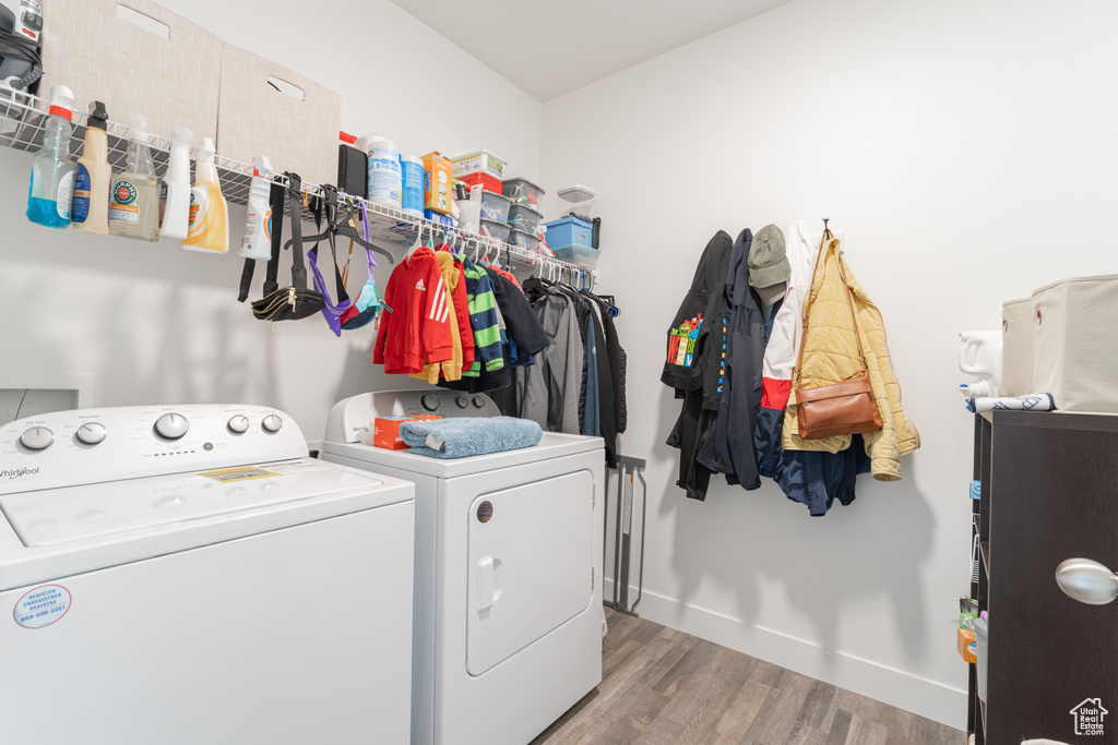 Laundry room featuring separate washer and dryer, wood finished floors, and baseboards