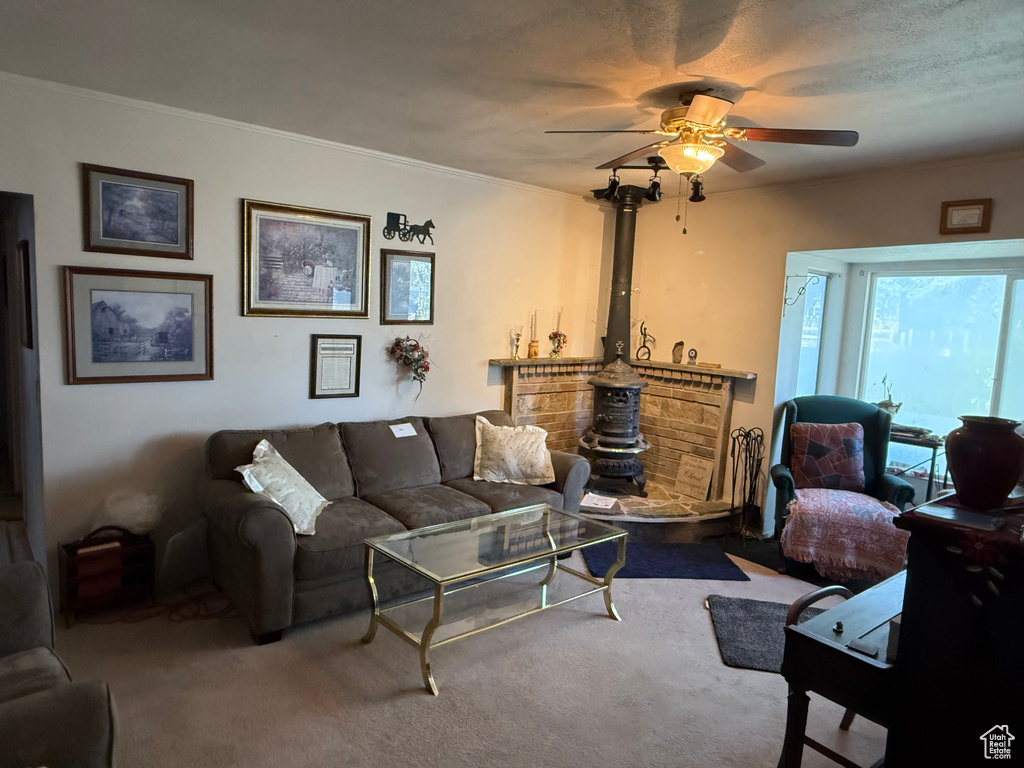 Carpeted living room with a ceiling fan and ornamental molding