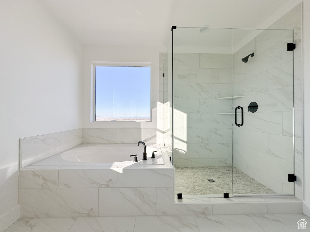 Full bath with a bath, a shower stall, and marble look tile flooring