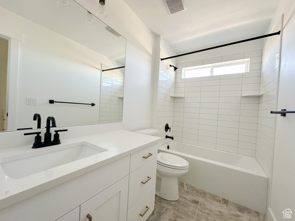 Full bath with vanity, toilet, and  shower combination