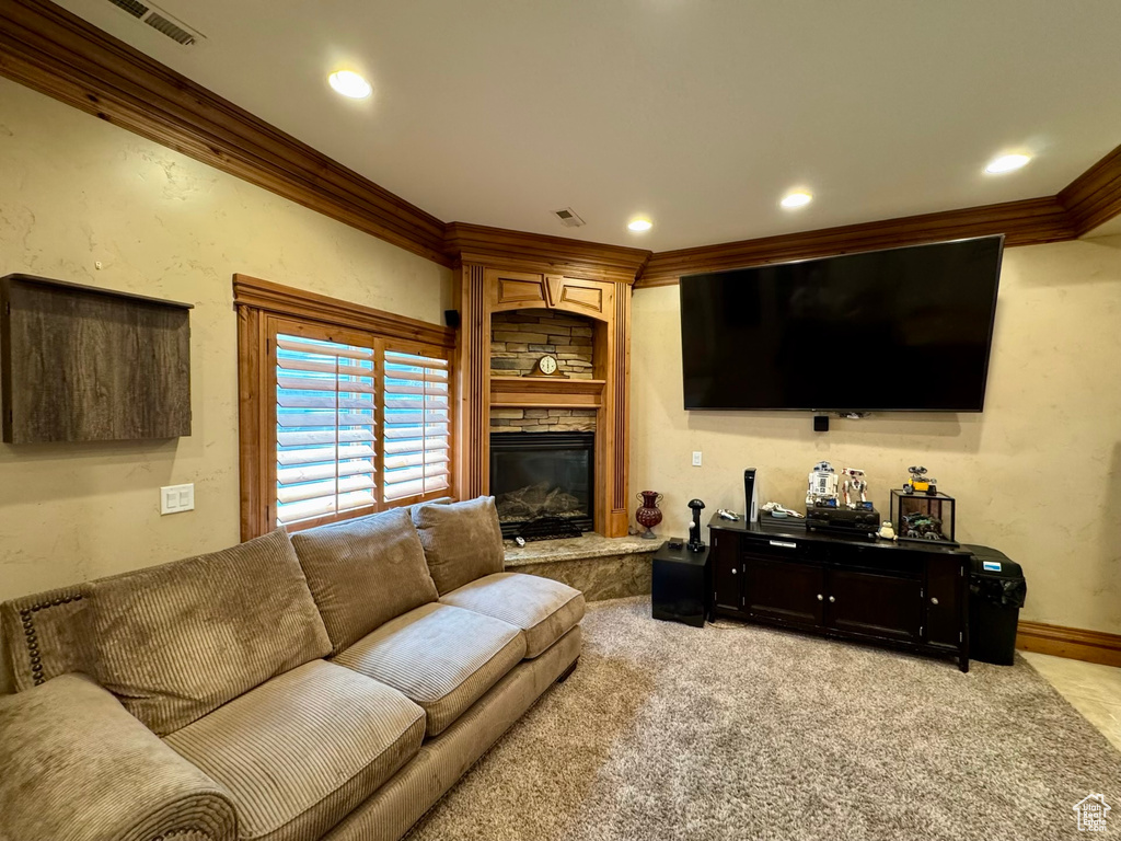 Living room with crown molding, a fireplace, light colored carpet, recessed lighting, and baseboards