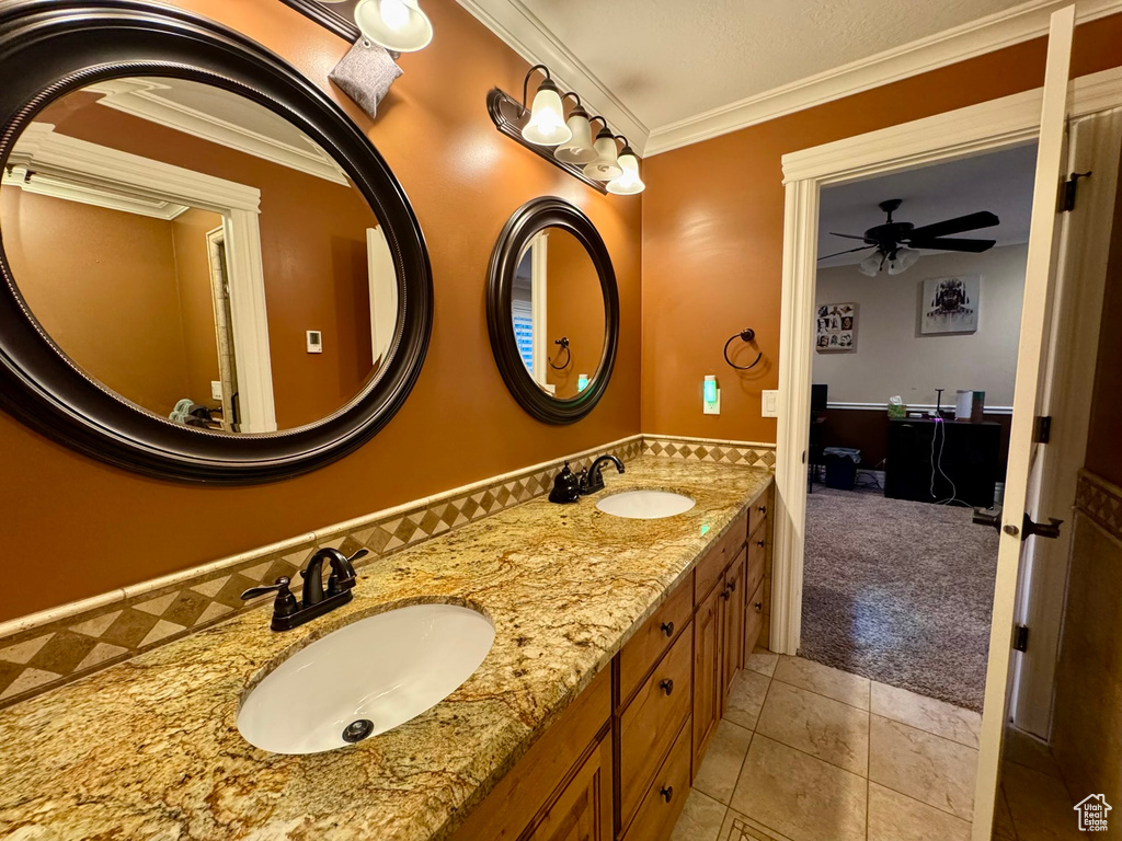 Full bathroom with tile patterned floors, double vanity, ceiling fan, and crown molding