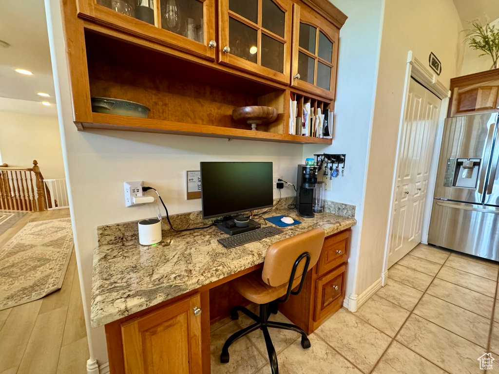 Office space featuring built in desk, baseboards, and light tile patterned flooring