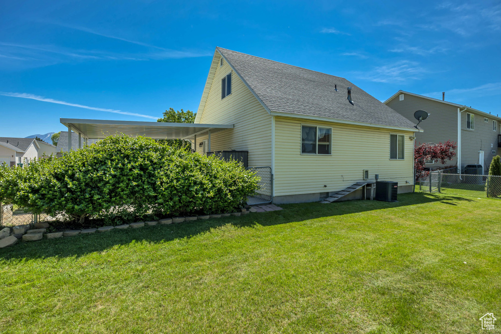 Rear view of property featuring roof with shingles and central air condition unit